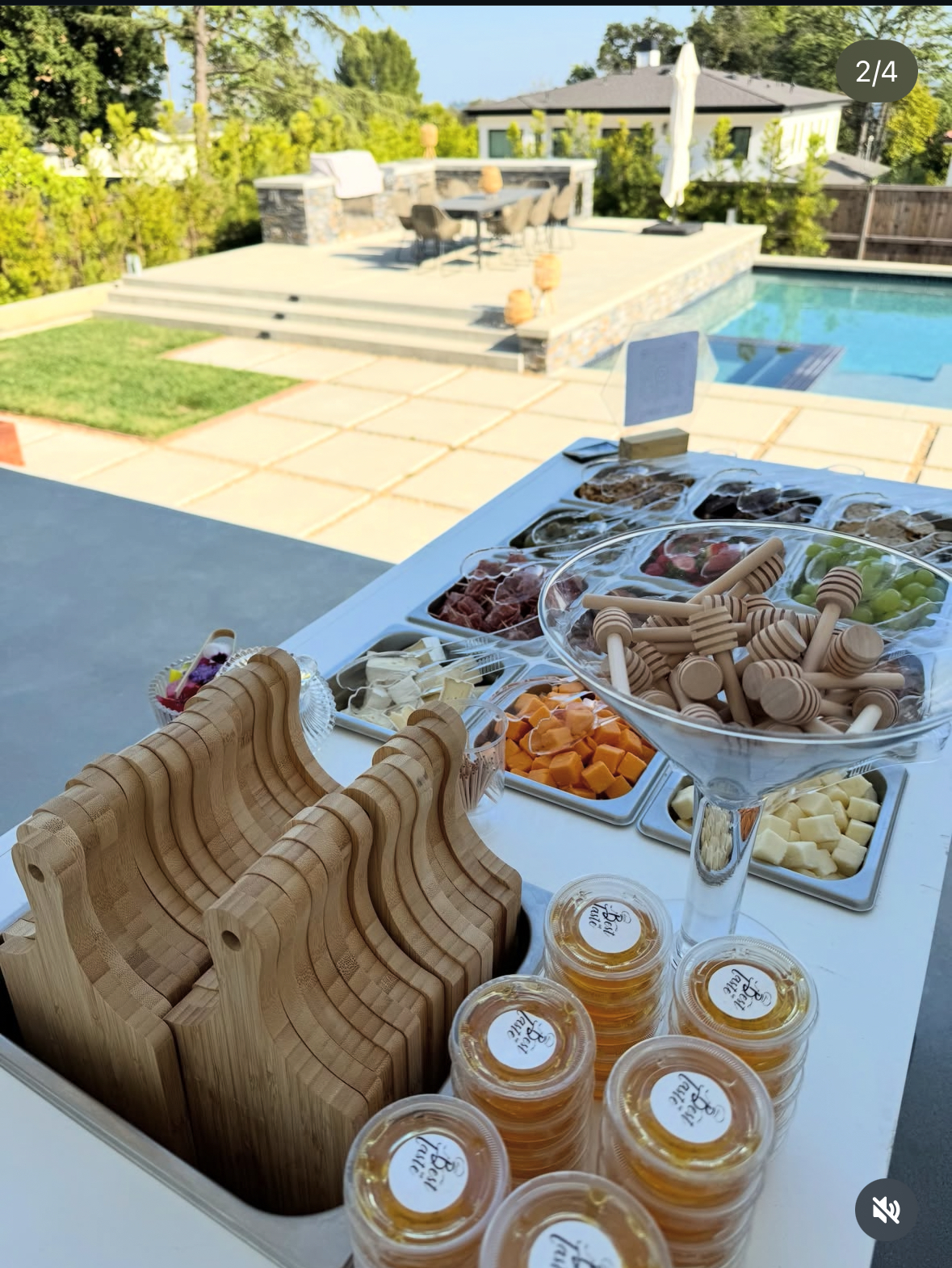 Poolside charcuterie setup with honey cups and wooden boards